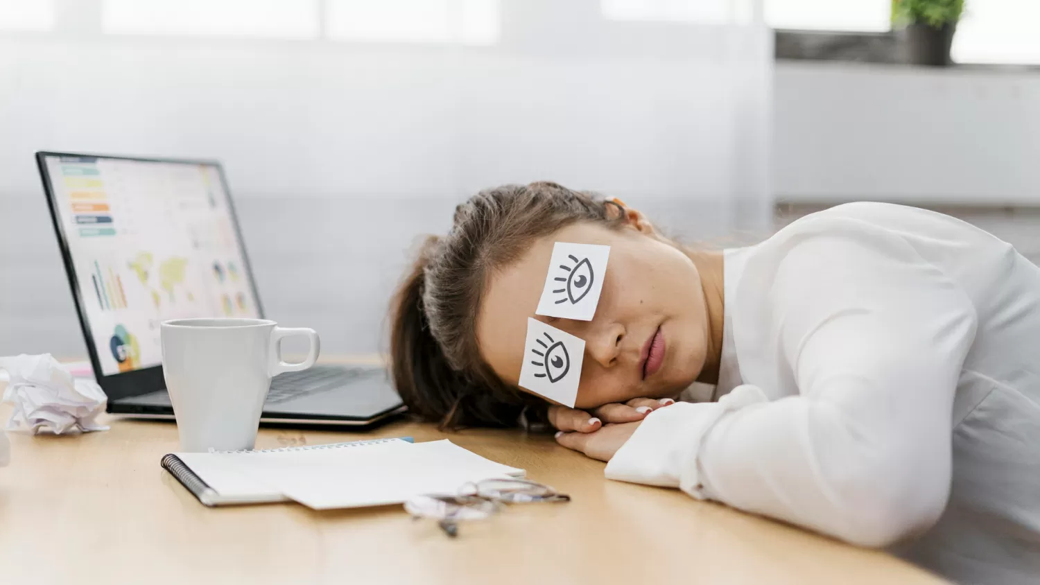 Imprenditrice stanca che copre gli occhi con gli occhi disegnati su carta