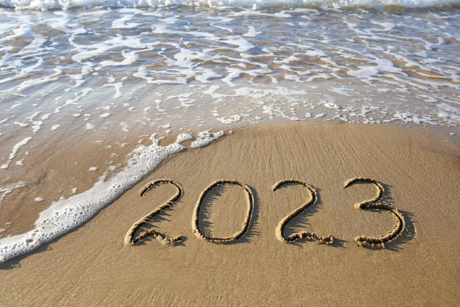 2023 year written sandy beach sea top view flat lay